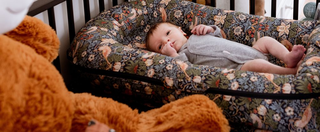 jongentje geboren na geslachtsbepaling en ligt in een box met knuffelbeer